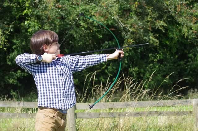 boy shooting an arrow at summer camp